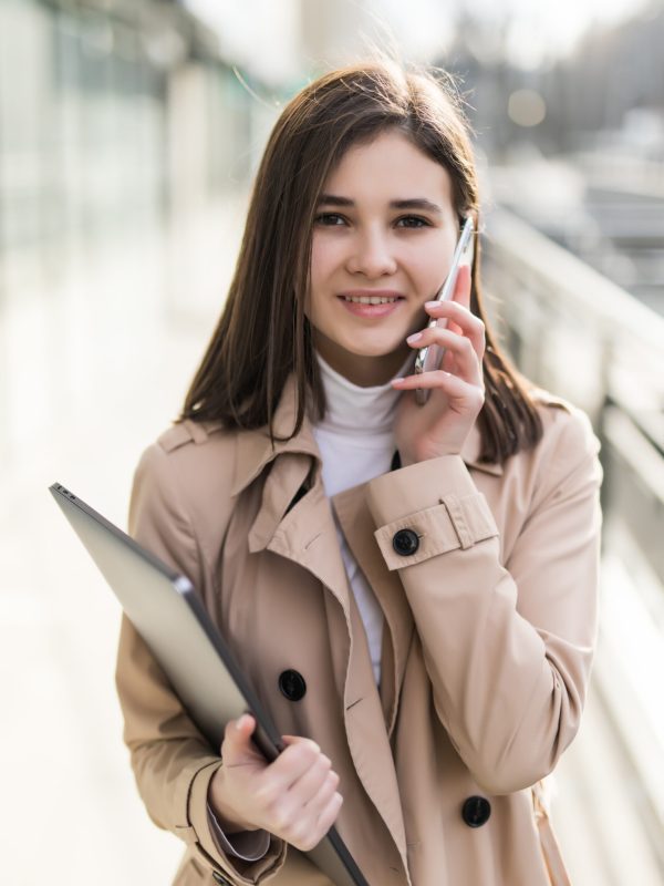 model with laptop in her hands have a phonecall on her phone
